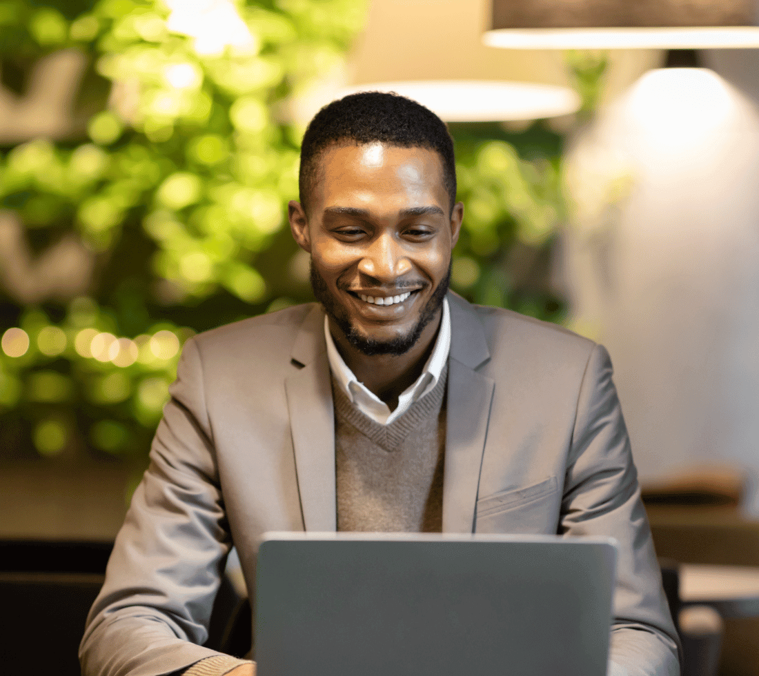 Black man smiling at laptop