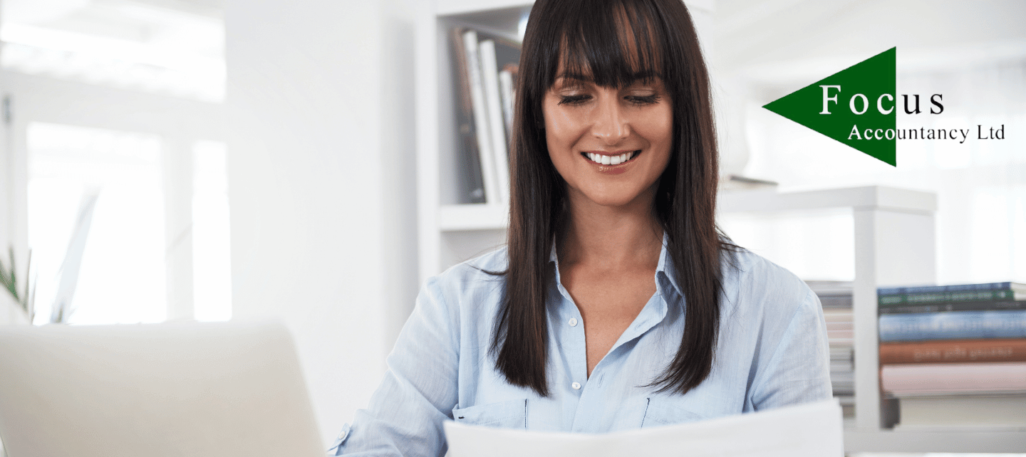 Focus Accountancy customer looking at paperwork whilst sitting at her desk