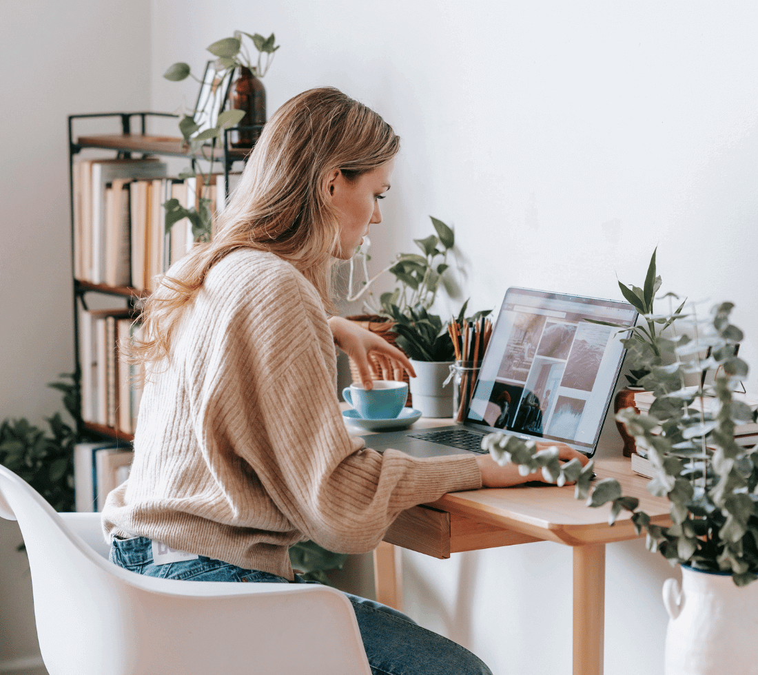 Female freelancer sits at a desk working on a laptop