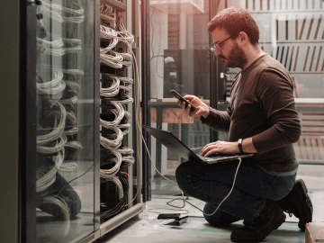 Male IT freelancer working in a server room